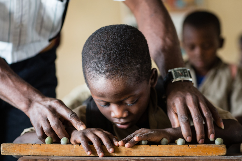 Tresor has a visual impairment and attends a mainstream school in Togo, via an inclusive education project run by HI. He learns Braille with the support of a mobile teacher.