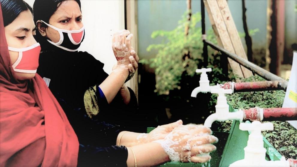 Women in garment ector washing hands during pandemic