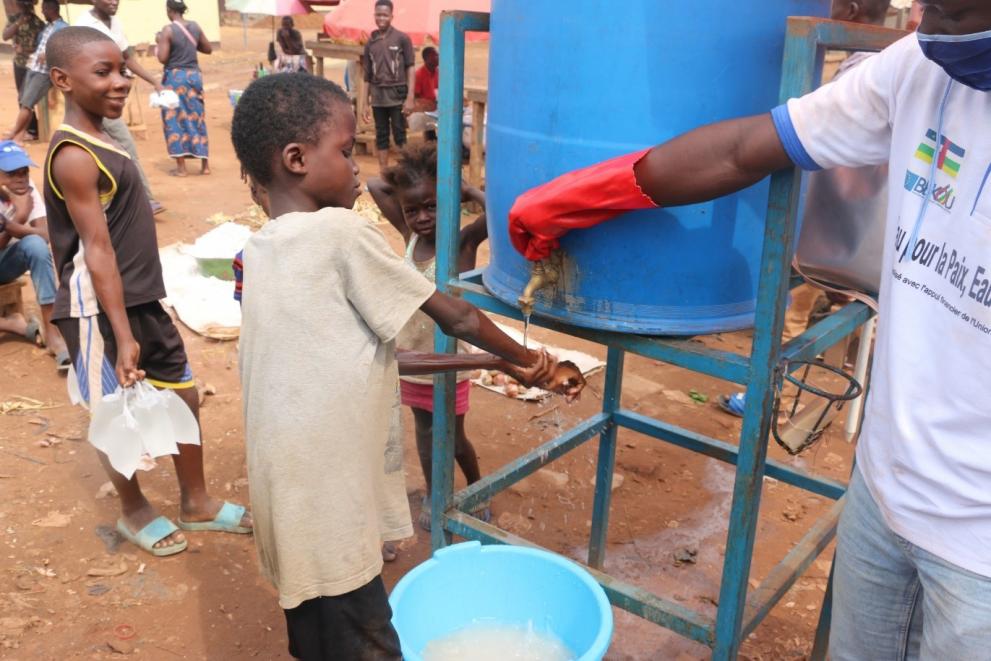 Un enfant se lave les mains dans une station de lavage des mains du site de SEGA © G. Bogangabe / UNICEF