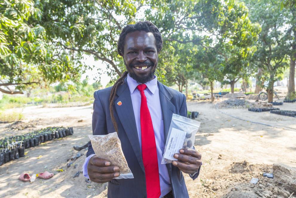 Zebron Mwalle, a seed collector for Choma tree nursery, stands for a portrait on Choma community farm in Zambia.