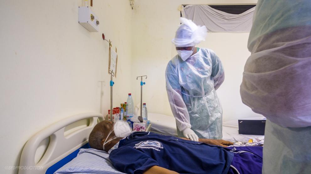 A health worker from ALIMA checks on a patient in a COVID treatment centre in Conakry
