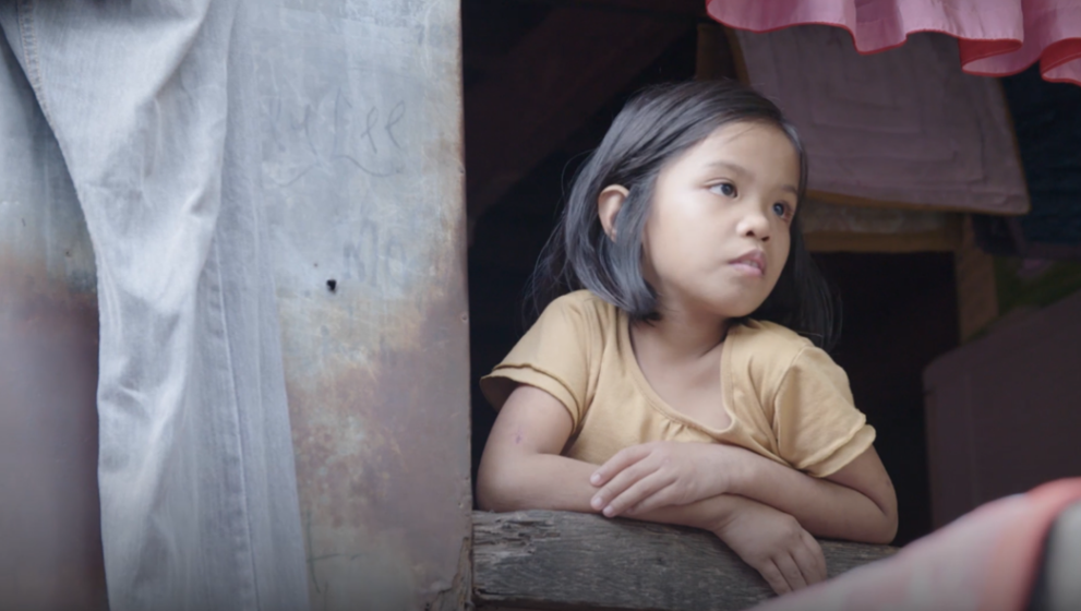 Young girl looking outside her home in the Pateros district in Metro Manila