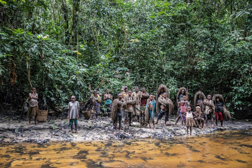 Indigenous people standing on a river side in the Congo Basin