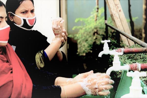 Women in garment sector washing hands during pandemic