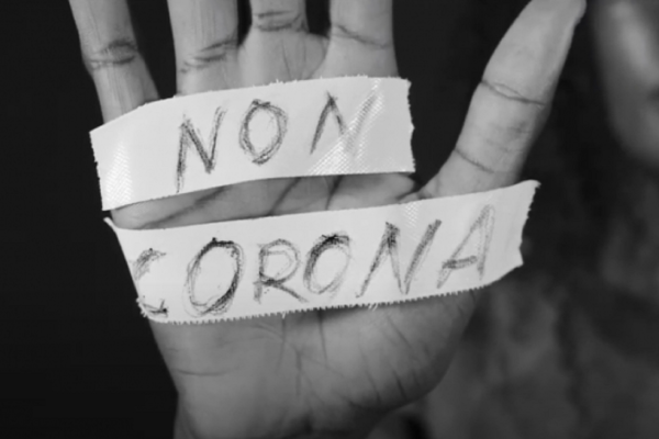 La paume d'une personne avec une bande qui dit "Non Corona"
