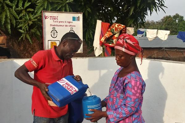Deux personnes s'occupant de l'approvisionnement en chlore pour eau potable