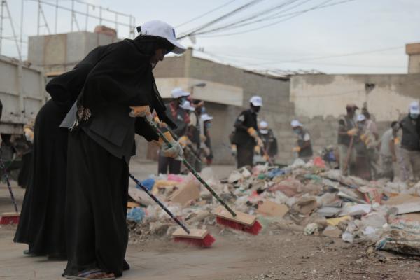 Yemeni woman collecting waste.